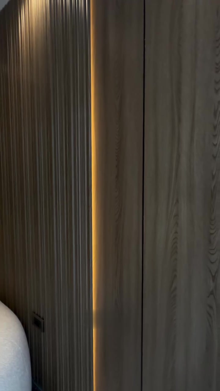 Muro de madera con tira LED vertical de luz cálida